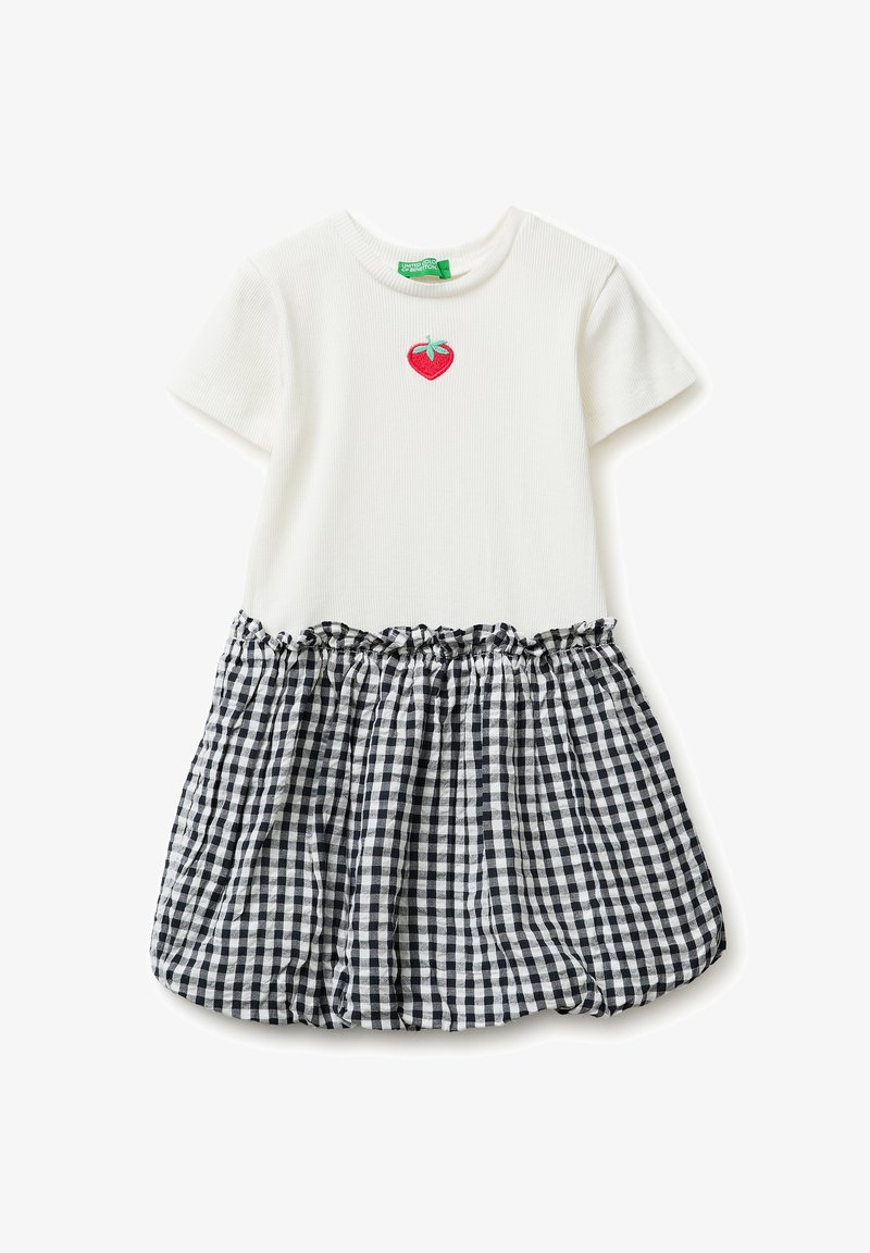 Robe blanche à manches courtes avec haut côtelé, petite broderie rouge de fraise sur la poitrine, et jupe froncée à carreaux noir et blanc.