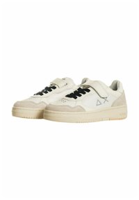 Sneakers bianchi in pelle con lacci neri e dettagli in suede grigio. Presentano una striscia in velcro e una suola in gomma testurizzata. Design minimalista.