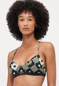 Svart og grønn blomstret bikini topp med trekantkopper, tynne justerbare stropper og en merket kant. Har et rutete mønster med store blomster.