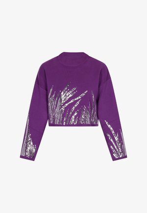 Sweatshirt violet cropped avec des manches longues. Présente des motifs de type herbe en sequins argentés sur le devant et les manches. Texture douce.