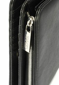Czarny skórzany portfel z zamknięciem na srebrny zamek błyskawiczny. Posiada poziome przeszycia oraz zewnętrzną etykietę obok zamka.