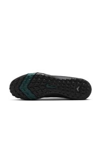 Nike shoe sole featuring rubber material, black color with green accents, textured grip pattern, and distinctive logo detail.