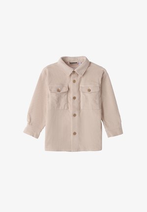 Chaqueta de botonadura de pana beige con mangas largas, dos bolsillos en el pecho con solapa y botones de madera sobre un fondo blanco.