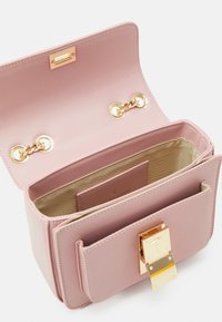 Różowa skórzana torba z zapięciem na złoty zamek, wyposażona w dwukolorowe wnętrze, podwójne łańcuchowe okucia oraz kompaktowy prostokątny kształt.
