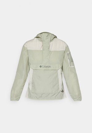 Világoszöld dzseki krémszínű panellel, félig cipzáros elöl, kapucnival és hálós zsebbel. A Columbia logója és rugalmas mandzsettái biztosítják a testhezálló megjelenést.