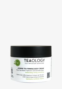 Coperchio nero e barattolo bianco della Crema Fissante per il Corpo al Tè di Gelsomino di Teaology. L'etichetta presenta grafiche di tè verde, con informazioni sul prodotto e codice QR.