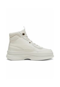 High-top sneakers in white leather with a textured finish, featuring a thick, ridged sole and metal eyelets for laces.