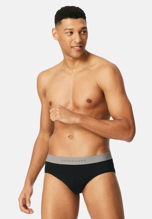 Boxer-briefs noirs pour hommes avec une ceinture grise portant le nom de la marque "Schiesser" dans une police simple, conçus pour le confort et l'ajustement.