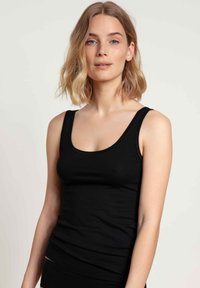 Black sleeveless tank top made of soft fabric. Features a fitted design with a scoop neckline and smooth texture without patterns.