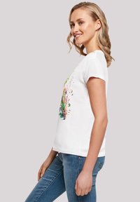 White cotton t-shirt with short sleeves, featuring a colorful floral design on the front. Worn with blue denim jeans.