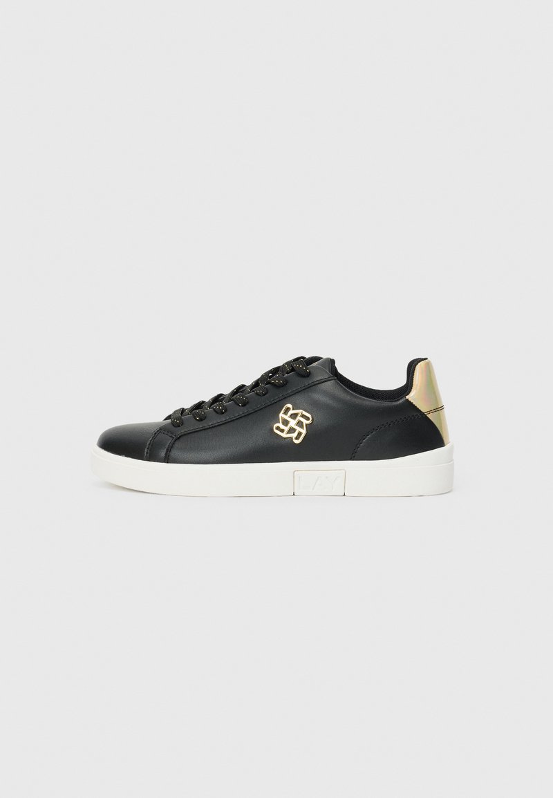 Sneaker in pelle nera con punta arrotondata, lacci neri, dettaglio del logo dorato e accento iridescente sul tallone. Suola in gomma bianca. Design minimalista.