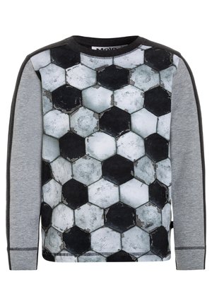 Camicia a maniche lunghe con un motivo esagonale che ricorda un pallone da calcio usurato, con maniche grigie e dettagli scuri. Tessuto morbido e texture visibile.
