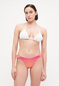 Haut de bikini triangle en tissu texturé blanc, accompagné d'un bas de maillot de bain taille basse dégradé du rose à l'orange, avec des accents élastiques sur les côtés.