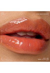 Glänzend orangefarbene Lippen leicht geöffnet, oberer Zahnbereich sichtbar, mit natürlicher Hauttextur um den Mund herum.