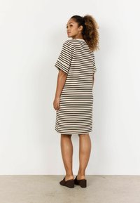 Brown and cream striped dress with short sleeves, straight cut, hip-length, side slits, paired with brown wedge mules.
