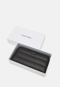 Calvin Klein LINE QUILT LARGE ZIP AROUND - Lompakko - black