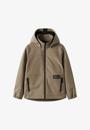 Beige hættejakke med sort lynlås, elastiske manchetter, to lynlåslommer og et lille mærke med teksten "Eventyr er den bedste måde at lære på."