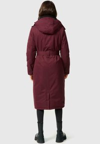 Bordeaux lange jas met een capuchon, een ceintuur in de taille en knoopmanchetten. Gemaakt van gestructureerde stof, met een slanke, moderne uitstraling.