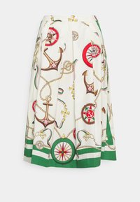 Jupe plissée blanche ornée de motifs nautiques colorés d'ancres et de barres, avec des accents verts et rouges à l'ourlet. Texture de tissu lisse.