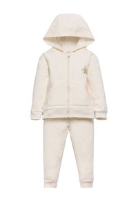 Conjunto de sudadera y pantalones para niños de color crema, con bolsillos frontales, cremallera, capucha y un detalle de estrellas verdes con rayas rosas en la chaqueta.