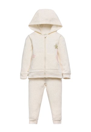 Conjunto de sudadera y pantalones para niños de color crema, con bolsillos frontales, cremallera, capucha y un detalle de estrellas verdes con rayas rosas en la chaqueta.