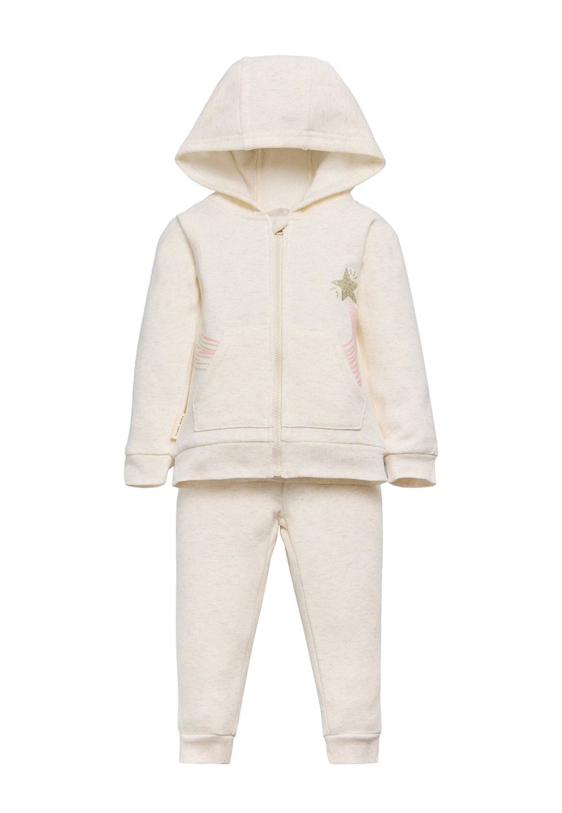 Conjunto de sudadera y pantalones para niños de color crema, con bolsillos frontales, cremallera, capucha y un detalle de estrellas verdes con rayas rosas en la chaqueta.