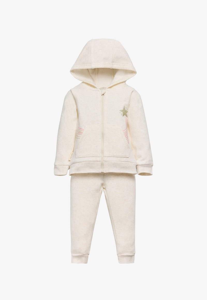 Conjunto de sudadera y pantalones para niños de color crema, con bolsillos frontales, cremallera, capucha y un detalle de estrellas verdes con rayas rosas en la chaqueta.