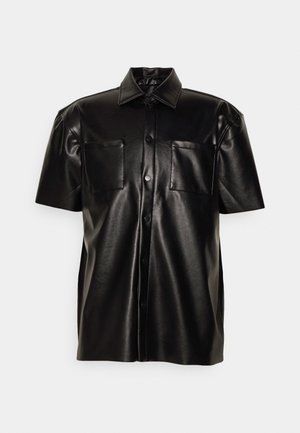 Černá tričko s krátkými rukávy z hladké umělé kůže, se dvěma kapsami na prsou a límečkem. Zapínání na knoflíky vpředu.