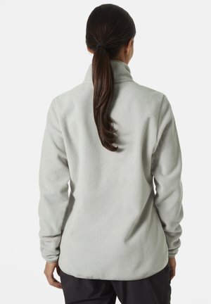 Chaqueta de forro polar gris claro con un cuello alto, mangas largas y una textura suave. Presenta un corte relajado y un dobladillo redondeado en la parte posterior.
