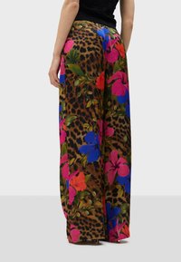 Wide-leg pantalons met een luipaardprint basis en levendige bloemenpatronen in roze, blauw en groen. Gemaakt van een lichtgewicht stof met een zachte textuur.