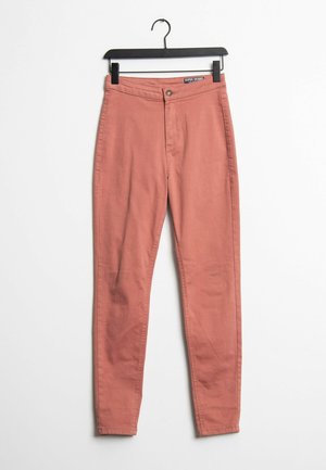 Roze super skinny jeans met knoop- en ritssluiting, een gladde stoftextuur en een slanke pasvorm. Hangt aan een zwarte haak.