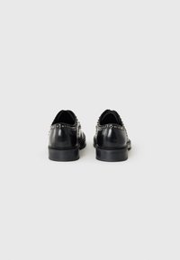 Black leather shoes featuring a smooth finish, rounded toes, and a decorative studded detail along the heel. Rubber soles for traction.