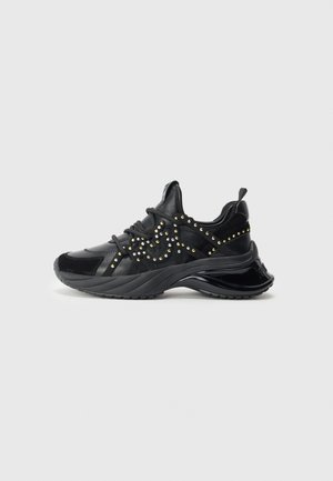 Sneaker nere caratterizzate da un mix di texture lisce e scamosciate, decorate con borchie dorate e un design di suola chunky per un'altezza aggiuntiva.