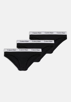 Tri čierne slipy Calvin Klein s bielymi elastickými pásikmi v páse s logom Calvin Klein v čiernom písme.