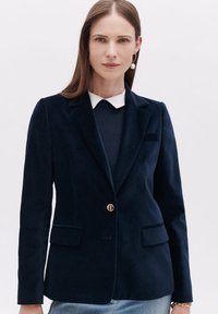 Navyblauwe op maat gemaakte blazer van zachte stof, met een enkele knoop, twee voortassen en een gelapte kraag.