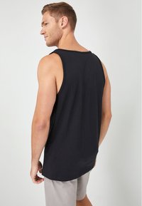 Schwarzes ärmelloses Tanktop aus weichem Stoff, mit rundem Ausschnitt und lässiger Passform sowie geradem Saum.