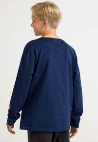 Mörkblå långärmad t-shirt i bomull, med rundad hals och avslappnad passform, med enkel sömnad och inga synliga mönster eller detaljer.