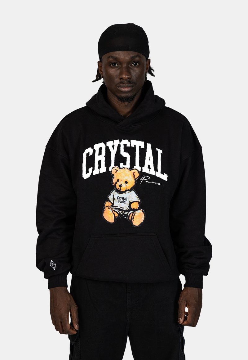 Zwarte hoodie met een grote graphic van een teddybeer die een shirt draagt met "Crystal Paris", voorzien van een voorzak en ribgebreide manchetten.