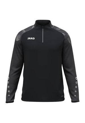 Sort langærmet sportstop med halv lynlås, "JAKO" logo på brystet, mønstrede skuldre og cirkulære designs på de nederste ærmer.