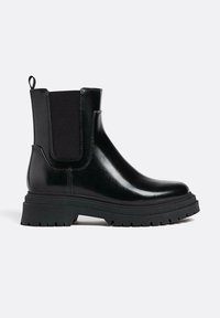 Svart skinn Chelsea-boots med kraftig sula, elastisk sidopanel, ankelhöjd och dragflik bak.