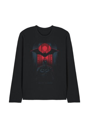Black long-sleeve shirt with a red window background, a large bat silhouette, and a dark figure of Batman below with text "I am the shadows."