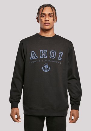 Black sweatshirt features a round neck, long sleeves, and a graphic print "AHOI" in blue, with a nautical design below the text.