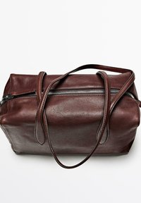 Borsa a mano in pelle marrone con una texture liscia, forma rettangolare, doppi manici e chiusura con zip superiore. Decorata con dettagli di cucitura visibili.