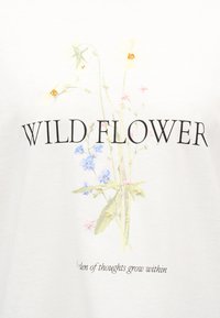Ανθικός σχεδιασμός με μικρά άγρια λουλούδια σε μπλε, ροζ και κίτρινες αποχρώσεις και κείμενο «WILD FLOWER» με μερικώς ορατή φράση από κάτω.