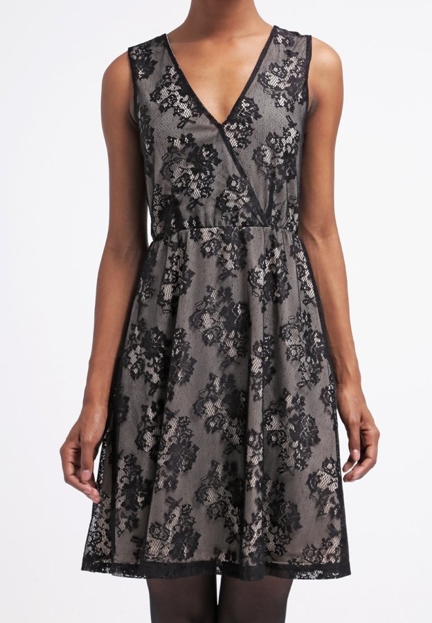 Robe en dentelle noire avec un col en V profond, un motif floral en dentelle, une taille cintrée et une jupe évasée à ourlet festonné.