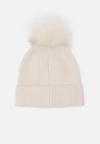 Cream ribbed knit beanie with a folded cuff and a soft, fluffy pom-pom at the top. Material appears warm and textured.