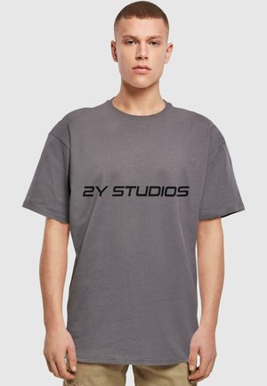 Grå bomull t-skjorte med rund hals og korte ermer, med "2Y STUDIOS" trykt i fet svart skrift over brystet.