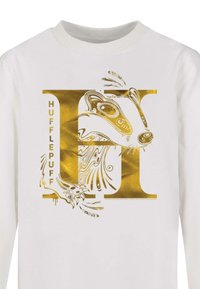 Hvid langærmet skjorte med et gyldent grafisk mønster af en grævling og bogstavet "H" for Hufflepuff, med indviklede mønstre og tekst.