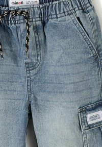 Shorts en denim bleu clair pour enfants avec taille élastique, cordon de serrage noir et blanc, poches latérales et une poche cargo avec une étiquette.