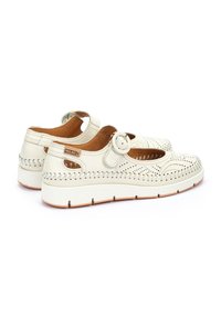 Chaussures en cuir blanc avec détails perforés, bout rond, bride de cheville avec boucle et coutures texturées sur les côtés ; semelle plate en caoutchouc.